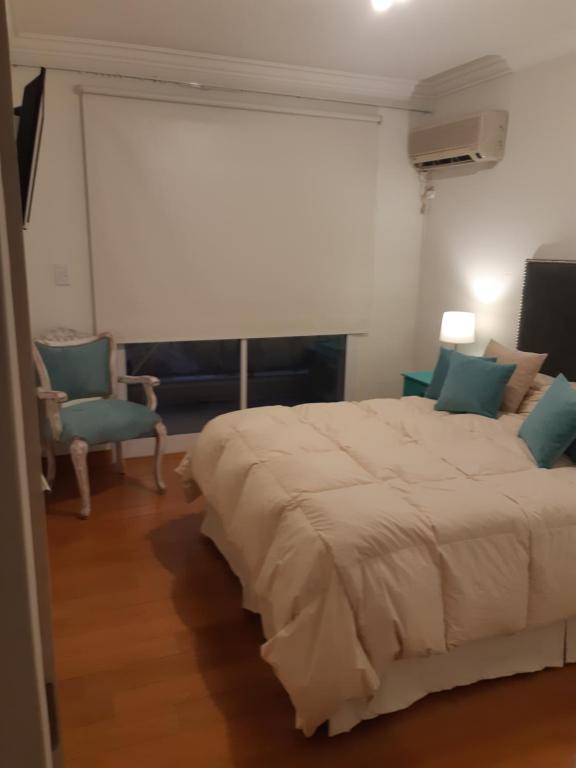 1 dormitorio con 1 cama blanca grande y 1 silla en Magia III en Salta