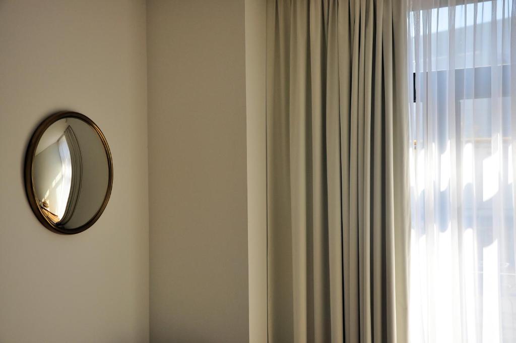 a mirror hanging on a wall next to a window at PicPorto Apartment in Porto