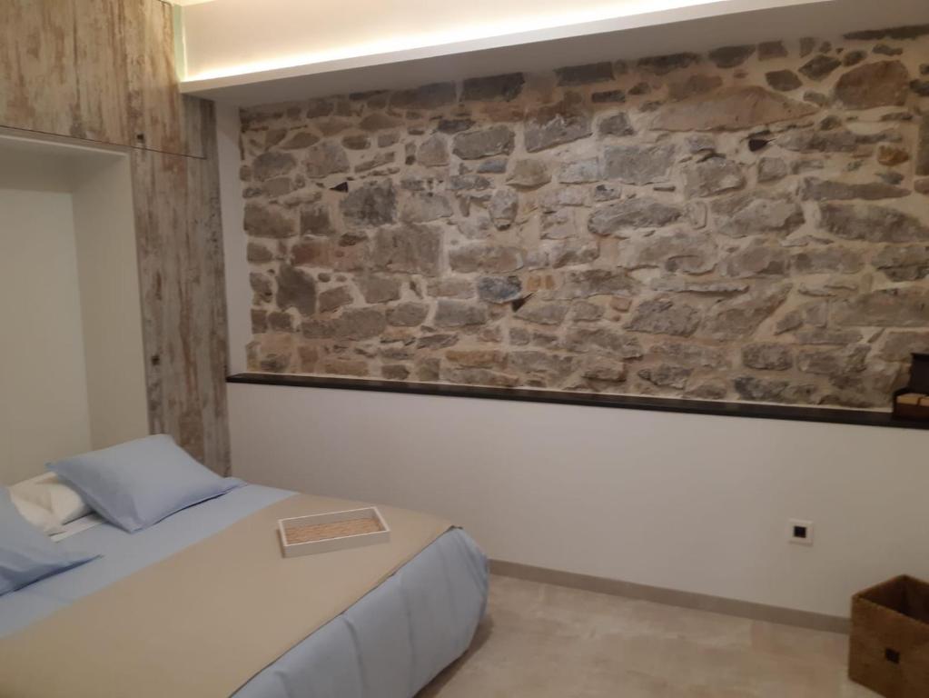 Un dormitorio con una pared de piedra y una cama en Cal Marsal en Aitona