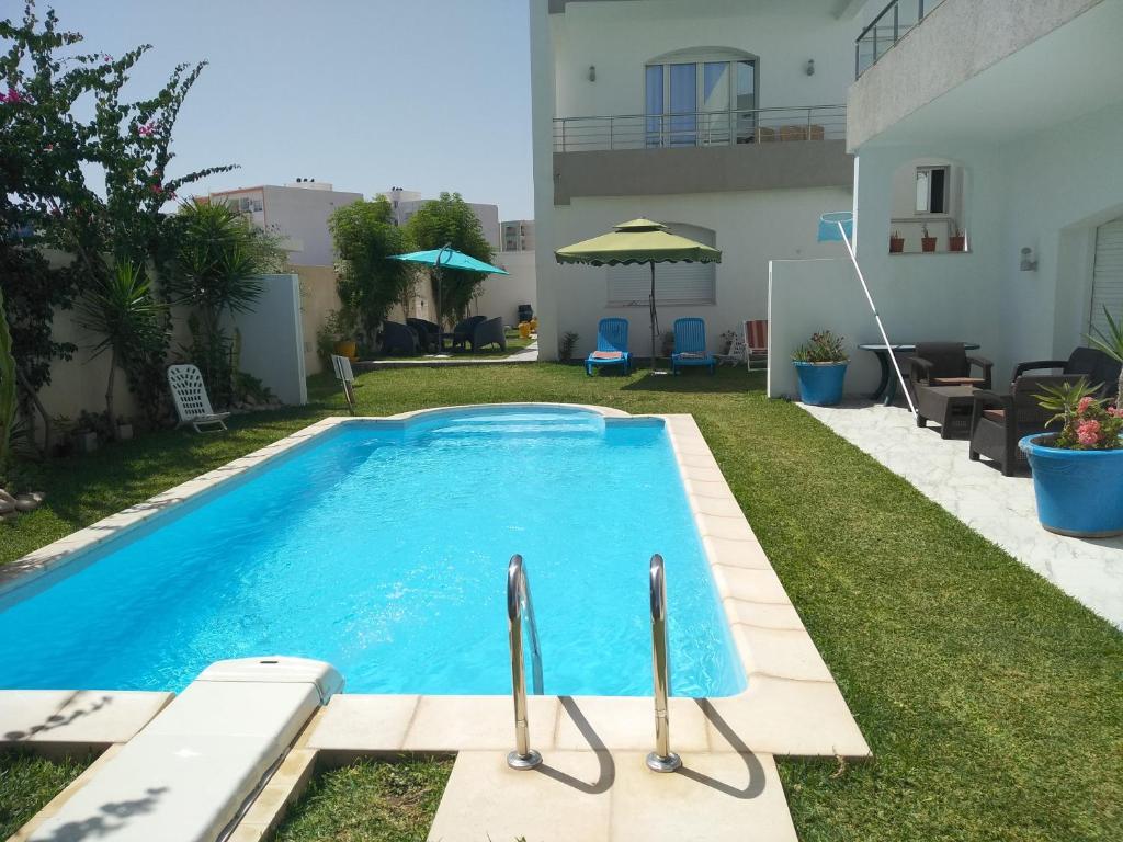 a swimming pool in the backyard of a house at Residence les Jasmins in Sousse