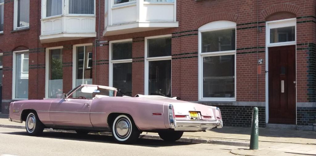 a purple car parked in front of a brick building at 74 Pijnboomstraat in The Hague