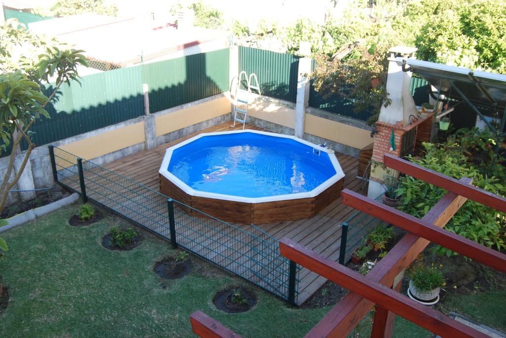a hot tub in a backyard with a fence at Lagoa House Albufeira in Lagoa de Albufeira