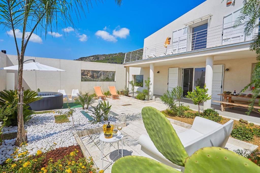 a house with a patio with a table and chairs at Villa Bonifato vista sulle campagne e sul mare siciliano alloggio per uso turistico in Alcamo