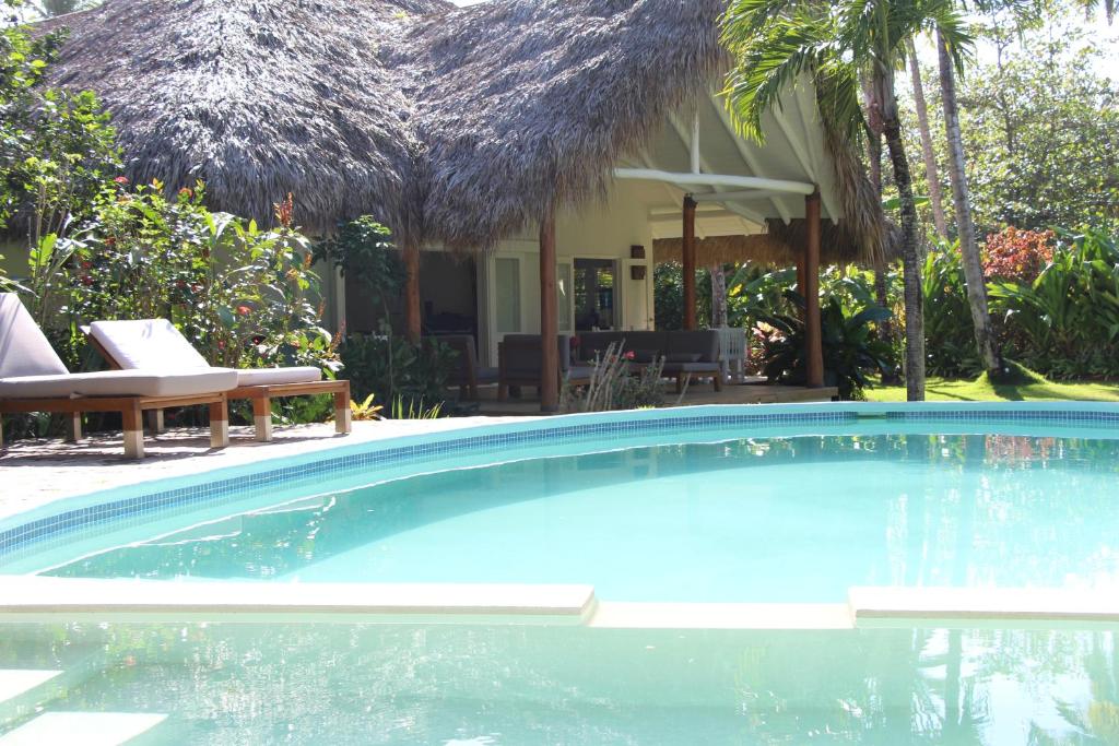 a swimming pool in front of a house at Caribbean Beach Villa Playa Bonita Las Terrenas in Las Terrenas