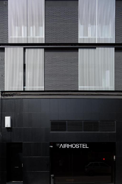 埃普拉特约布里加Airhostel Barcelona Airport 24h的一栋黑白相间的建筑，上面有 atositel 的标志