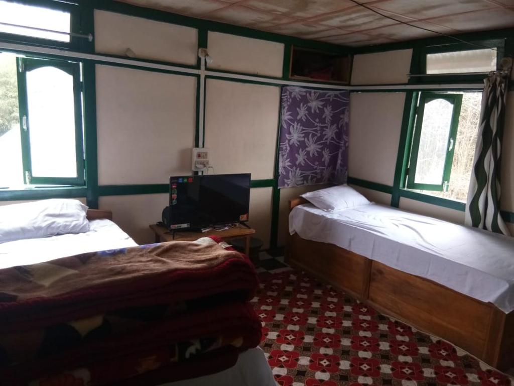 a room with two beds and a tv in it at Vamoose Nehabo in Hāpoli