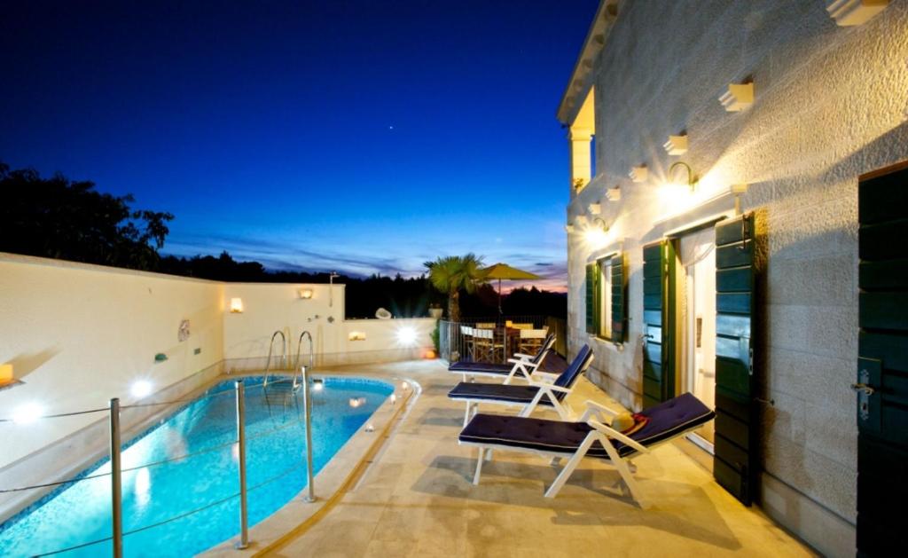 a villa with a swimming pool at night at Villa Serena in Mirce