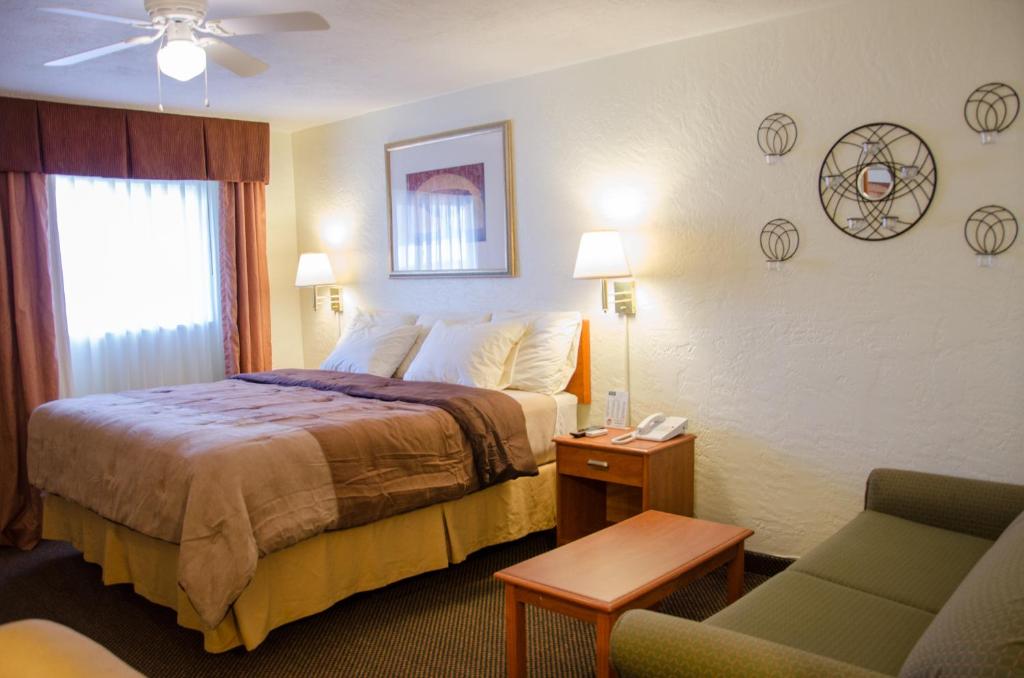 ein Hotelzimmer mit einem Bett und einem Stuhl in der Unterkunft Budget Inn &amp; Suites Colby in Colby