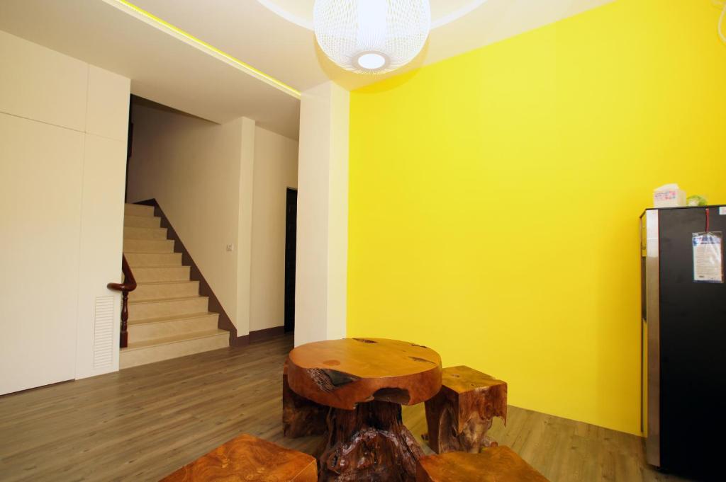 a room with a tree stump table and a yellow wall at Taitung Venice B&B in Taitung City