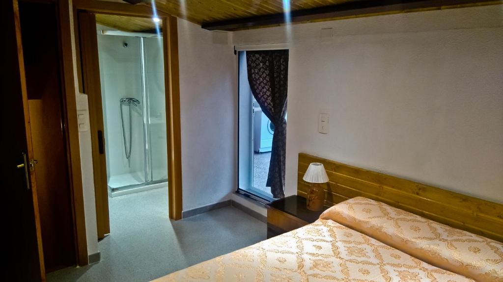 a bedroom with a bed and a window with a shower at La CasetA in Puebla de Benifasar