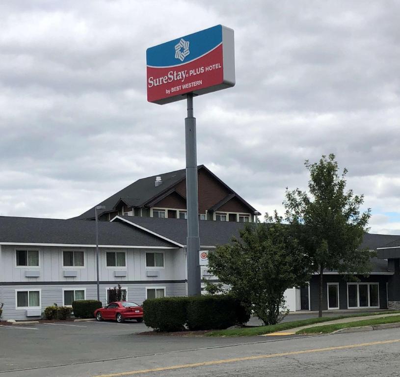 a sign in a parking lot in front of a building at SureStay Plus Hotel by Best Western Post Falls in Post Falls