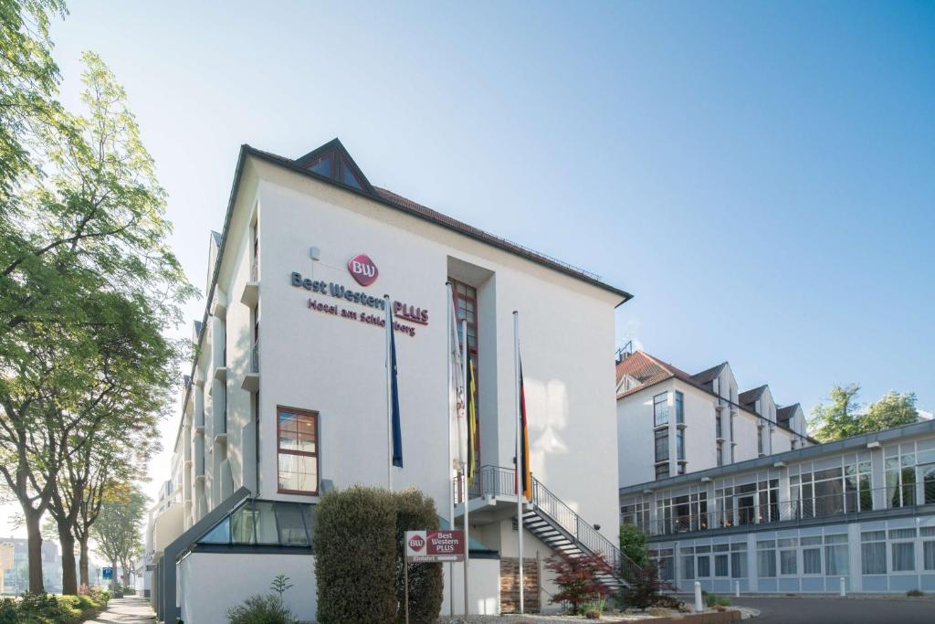 un bâtiment blanc avec un panneau sur son côté dans l'établissement Best Western Plus Hotel Am Schlossberg, à Nürtingen