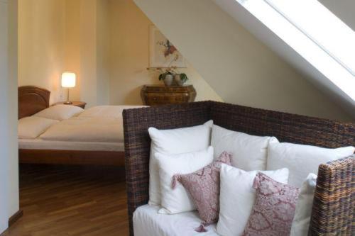 a bedroom with a bed and a couch with pillows at Hotel Csejtei in Feldbach