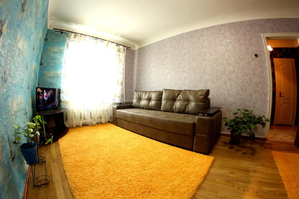 a living room with a couch and a yellow rug at Большая Перспективная 46 in Kropyvnytskyi