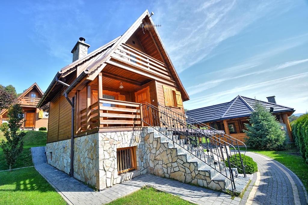 una casa de madera con una escalera que conduce a ella en Jaworina- Apartamenty, Domki i Pokoje, en Solina