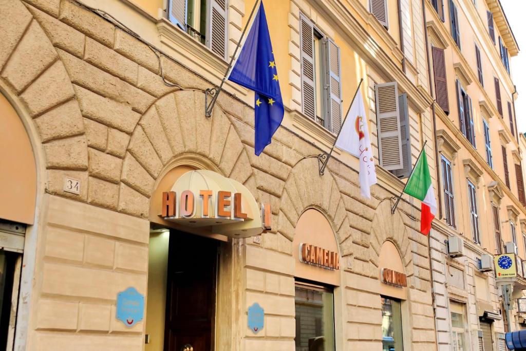 un hôtel arborant des drapeaux sur le côté d'un bâtiment dans l'établissement Hotel Camelia, à Rome