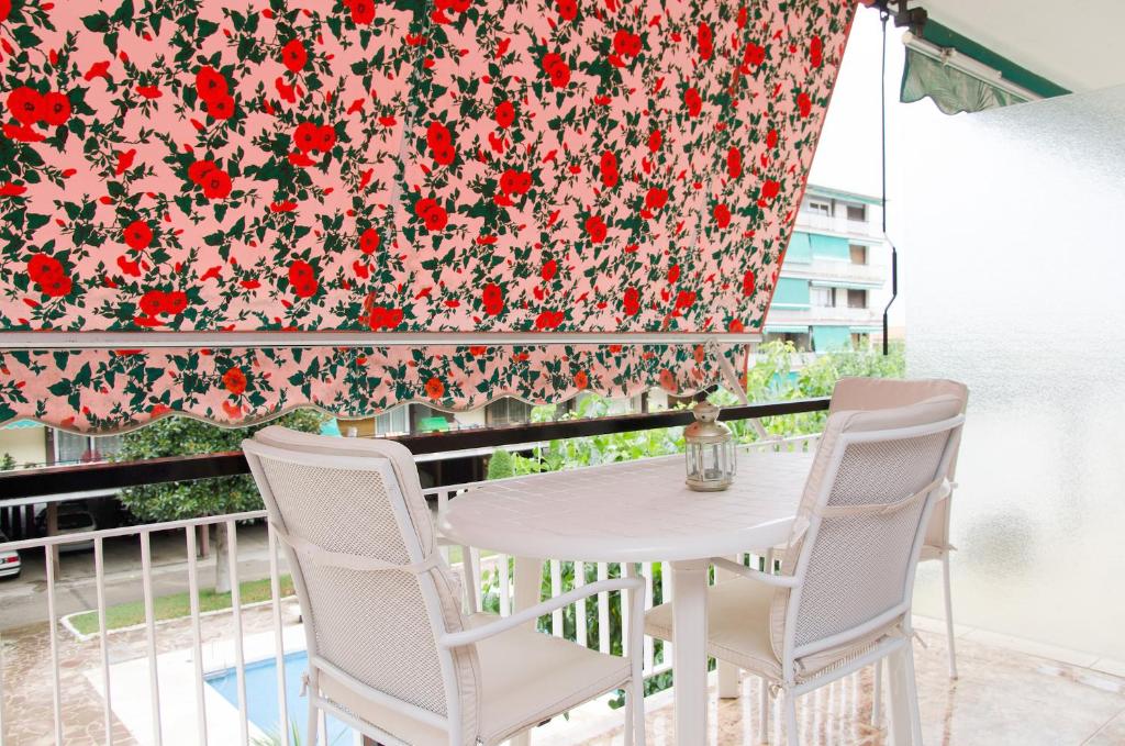 a table and chairs on a balcony with a curtain at Apartment Llavaneres I in Sant Andreu de Llavaneres