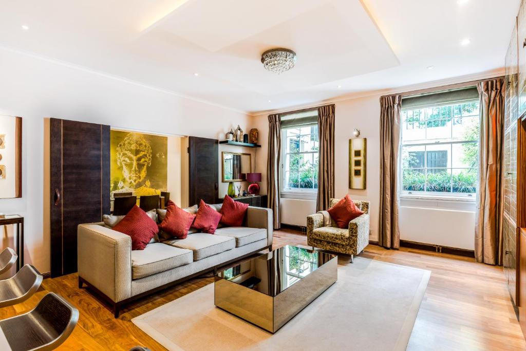 - un salon avec un canapé et des oreillers rouges dans l'établissement Garden Apartment in Central London, à Londres