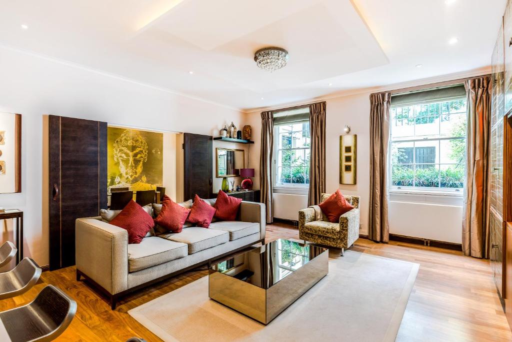 sala de estar con sofá y almohadas rojas en Garden Apartment in Central London en Londres