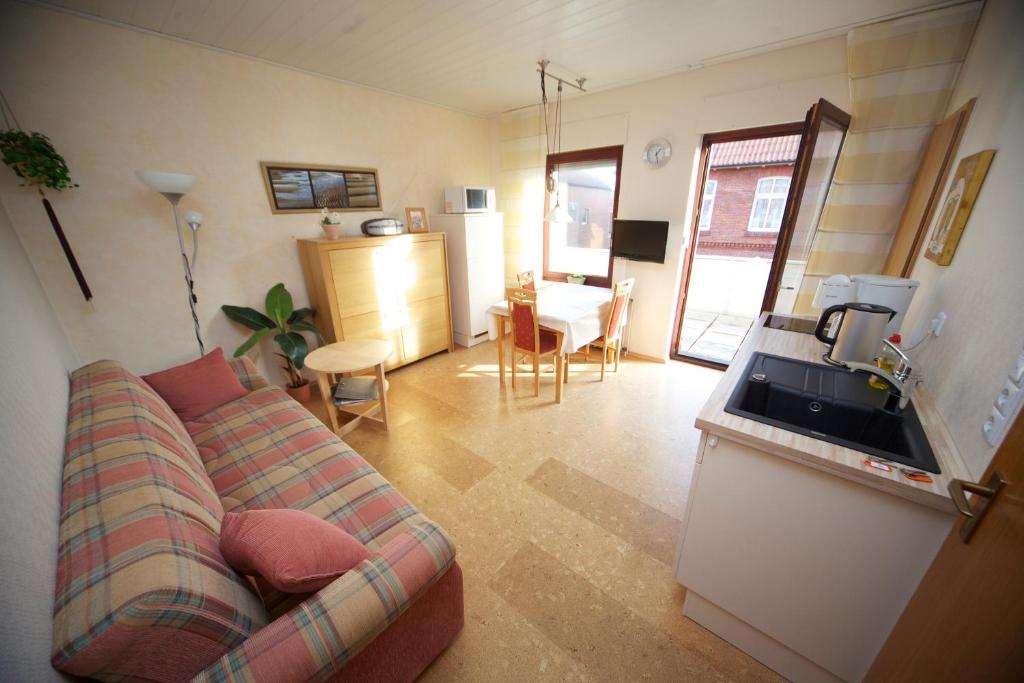 a living room with a couch and a kitchen at BORKUMUNTERKUNFT - WOH4 - IM HERZEN DER INSEL in Borkum