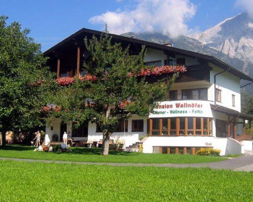 a building with a tree in front of it at Pension Wallnöfer in Mieming