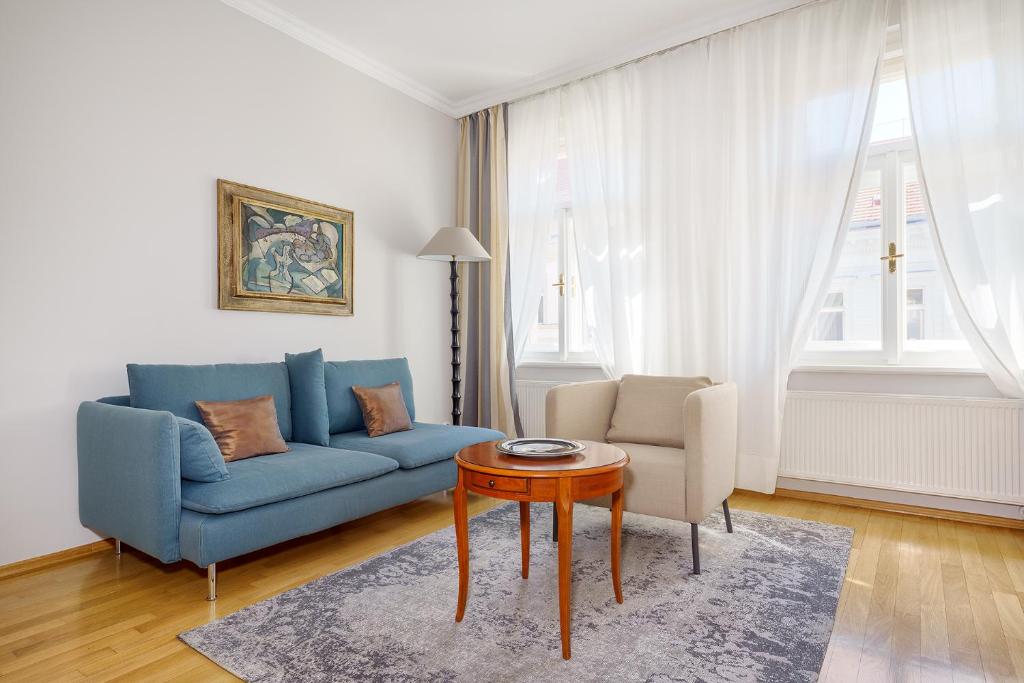 - un salon avec un canapé bleu et une table dans l'établissement Hunger Wall Residence, à Prague