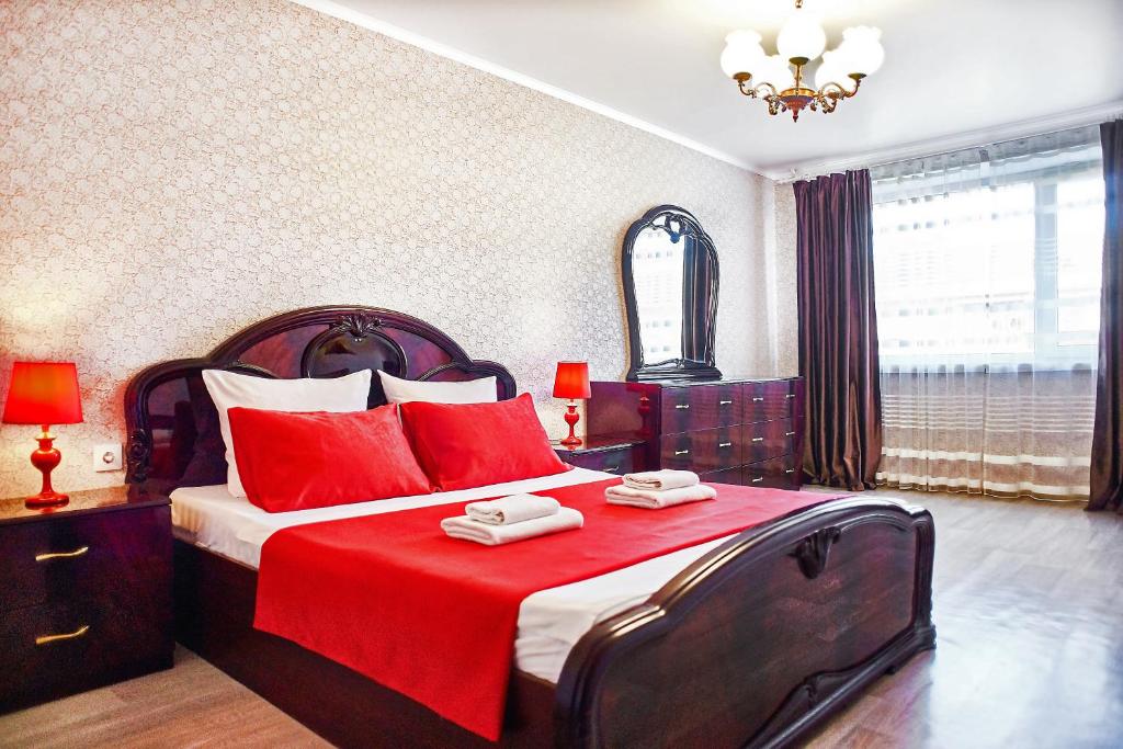 マグニトゴルスクにあるFive Stars Made In Comfortのベッドルーム1室(大型ベッド1台、赤い枕付)