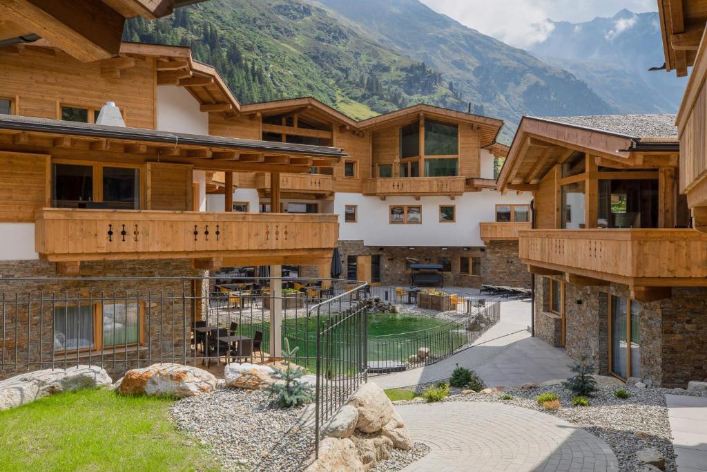 un edificio con una montaña en el fondo en das Chaletdorf - Pitztal, en Sankt Leonhard im Pitztal