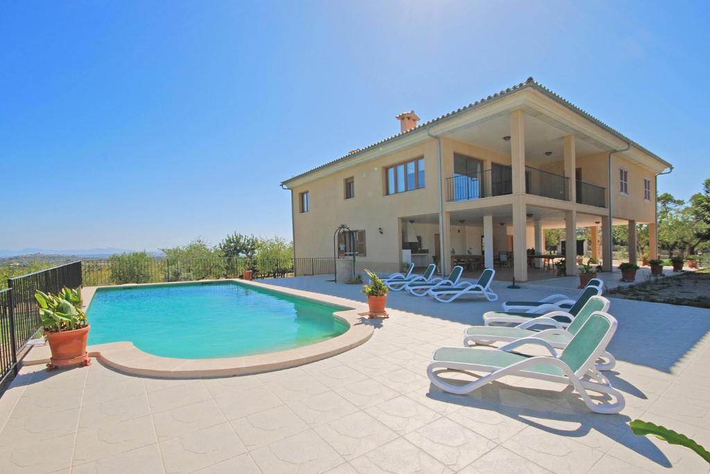 una casa con piscina y tumbonas en Villa Blanquerna, en Moscari