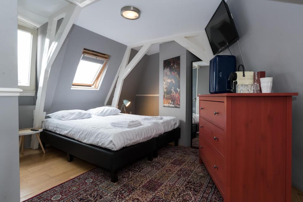 a bedroom with a bed with a red dresser at Westerpark Suites in Amsterdam
