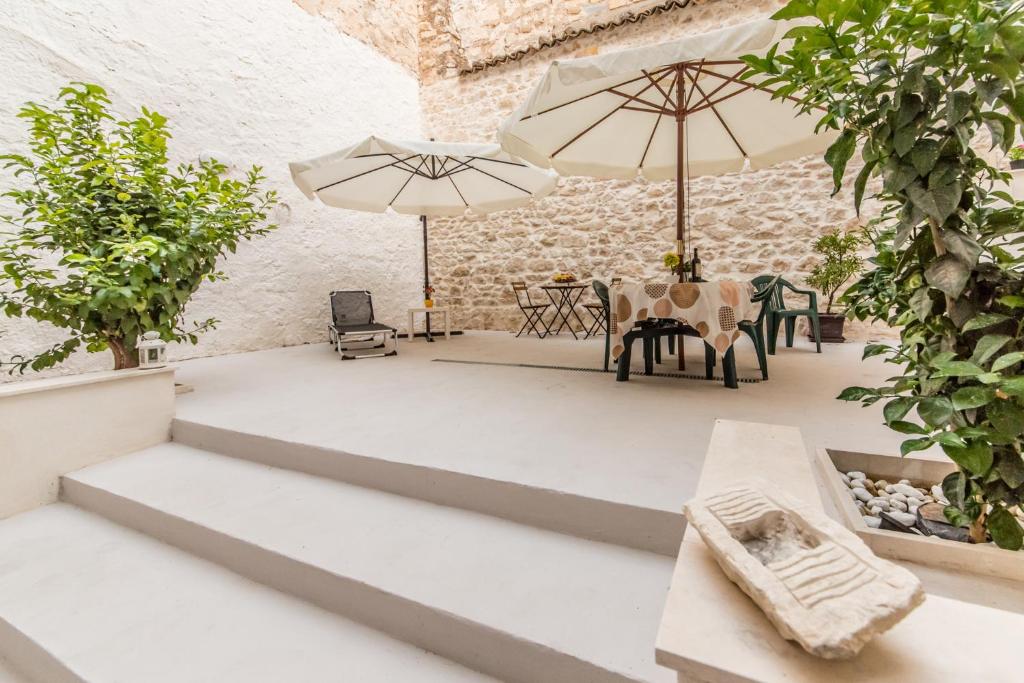 a patio with two umbrellas and a table and chairs at Carlentini house B&B in Comiso