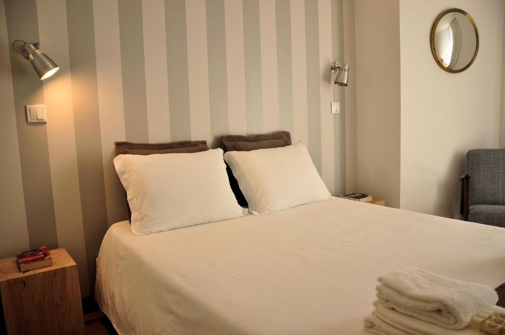 a bedroom with a bed with white sheets and a mirror at PicPorto Apartment in Porto