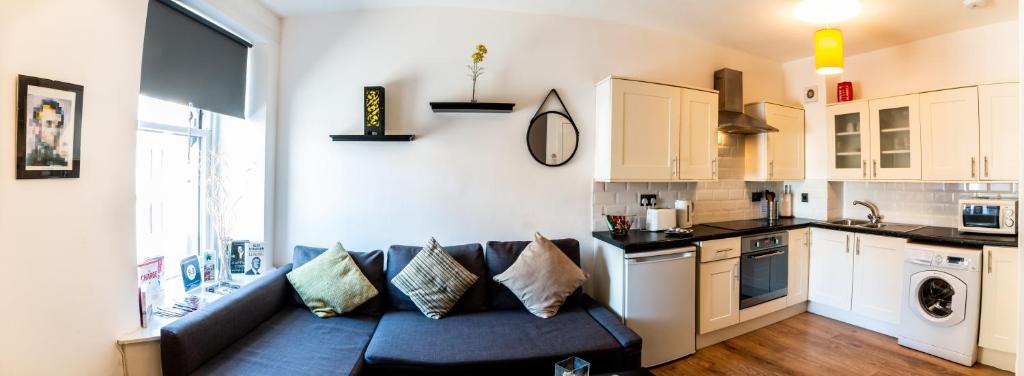 a living room with a blue couch in a kitchen at Mycosyapartments54 in Paisley