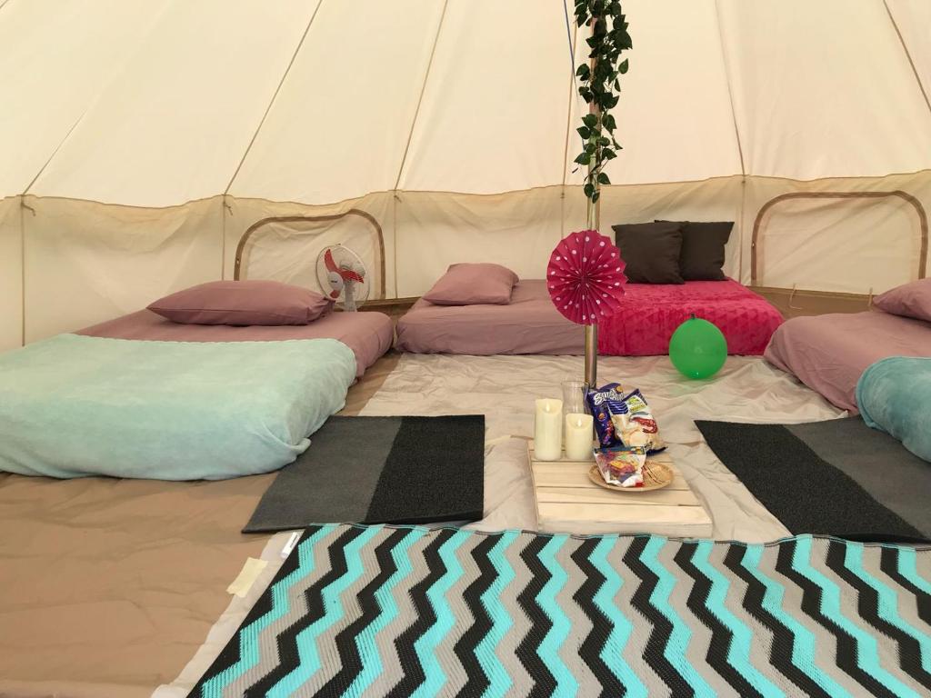 a tent with two beds and a table in it at Glamping Kaki - Large Bell Tent in Singapore