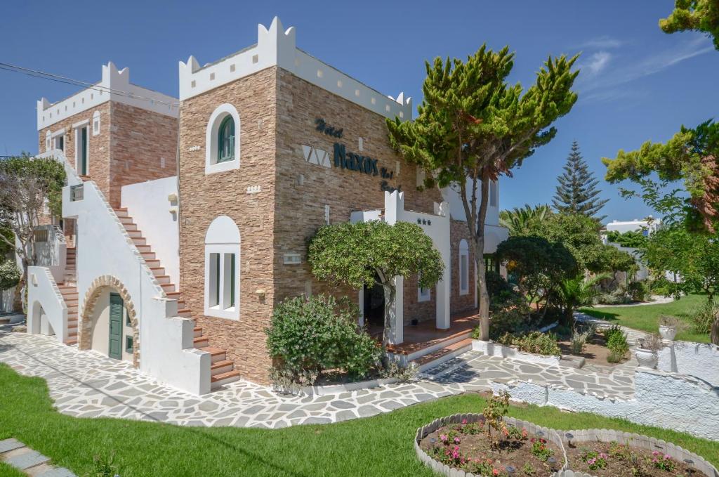 a large brick building with a clock on the front of it at Hotel Naxos Beach in Naxos Chora