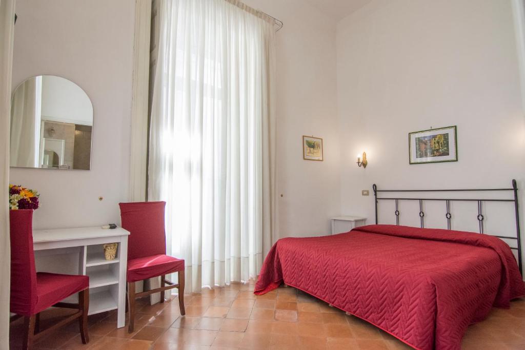a bedroom with a bed and a table and a mirror at Hotel Fontana in Amalfi