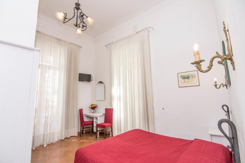 a bedroom with a table and chairs and a red bed at Hotel Fontana in Amalfi
