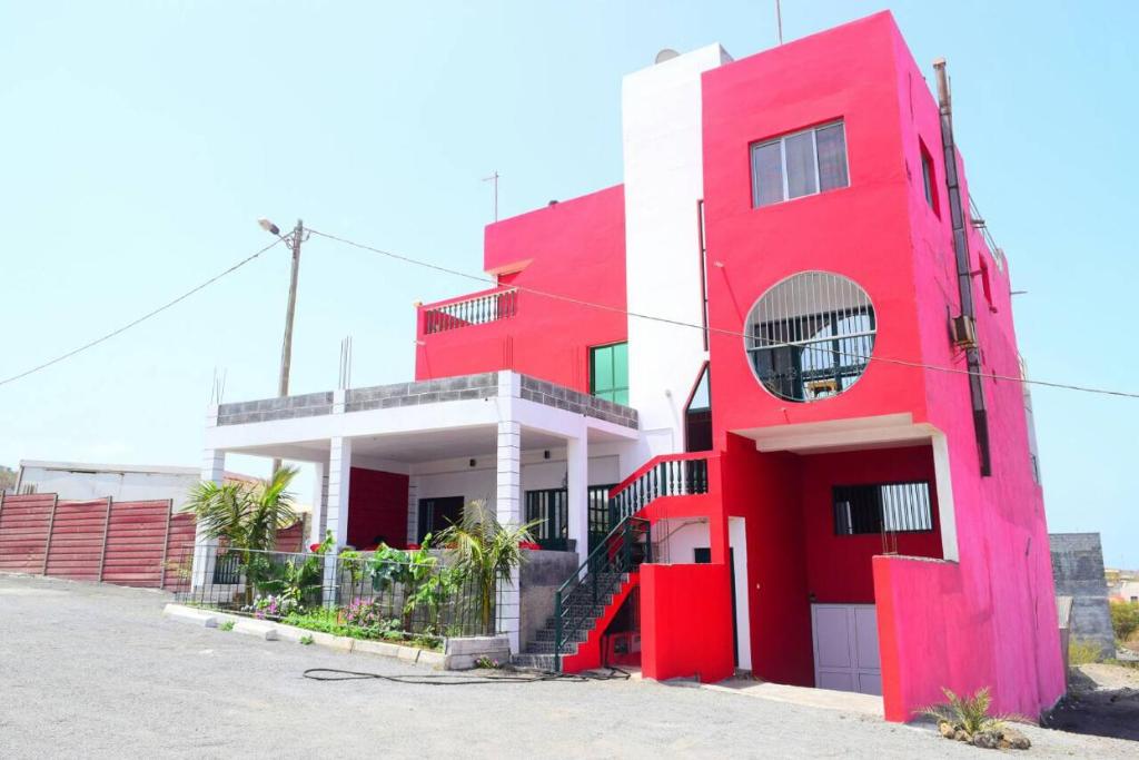 a red and white building with a redventh floor at Hotel Miramar Fogo Brava in São Filipe