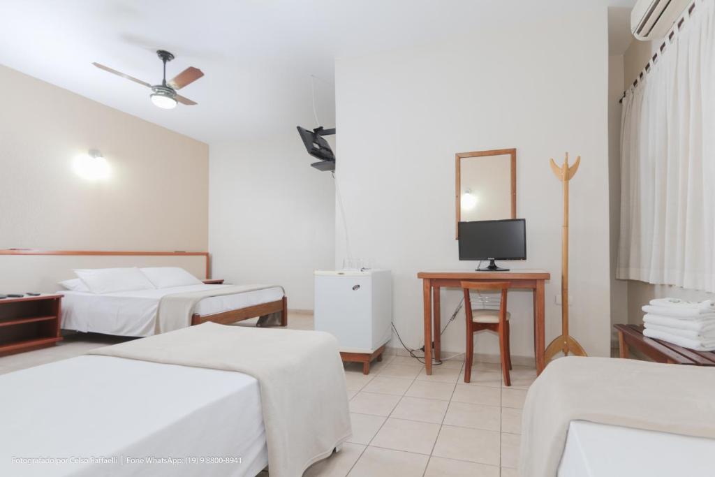 a hotel room with two beds and a television at Hotel Princeton in Piracicaba