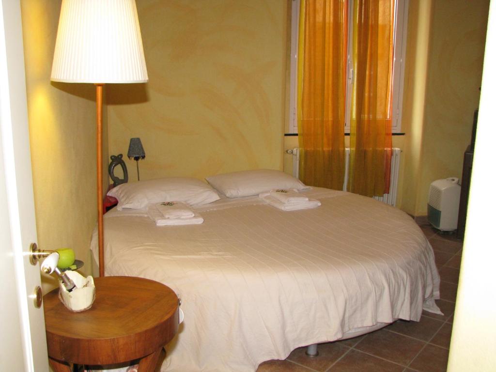 una camera da letto con un letto con una lampada e un tavolo di La Casa sul Fiume Aquila a Finale Ligure