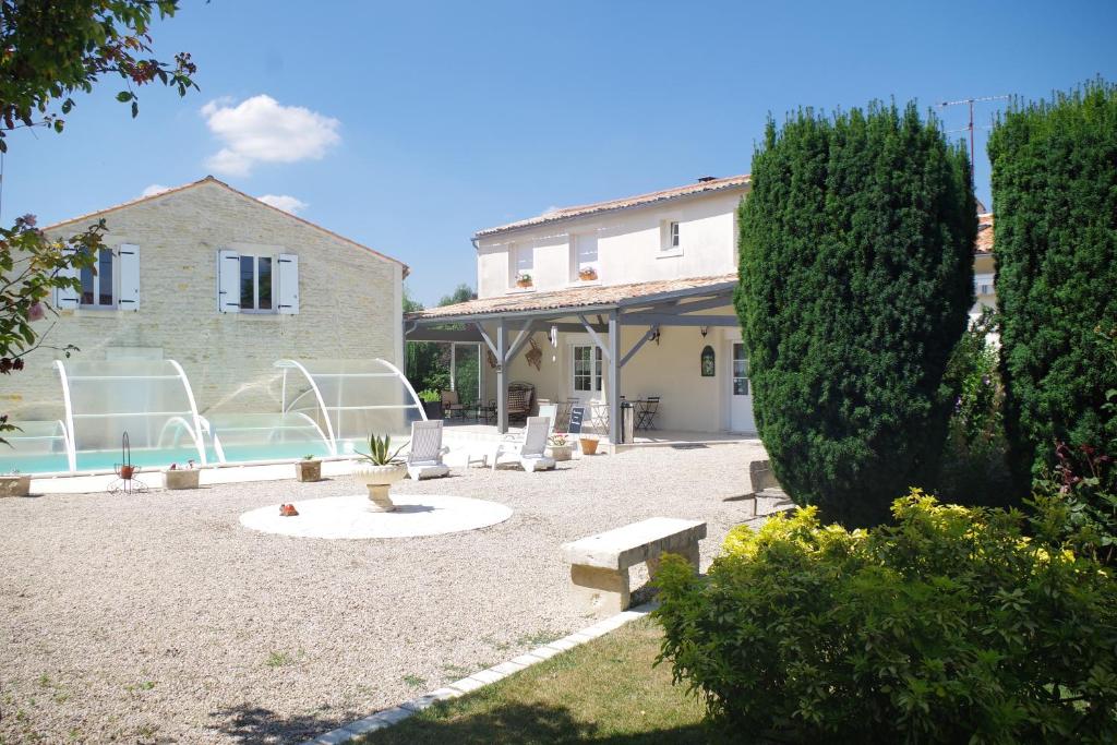 una casa con un patio con sillas y una piscina en Les Lavandières, en Saint-Hilaire-la-Palud