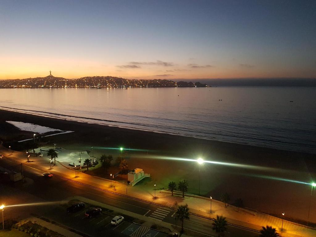 uitzicht op een stad met de oceaan in de nacht bij Departamento con vista al mar in Coquimbo
