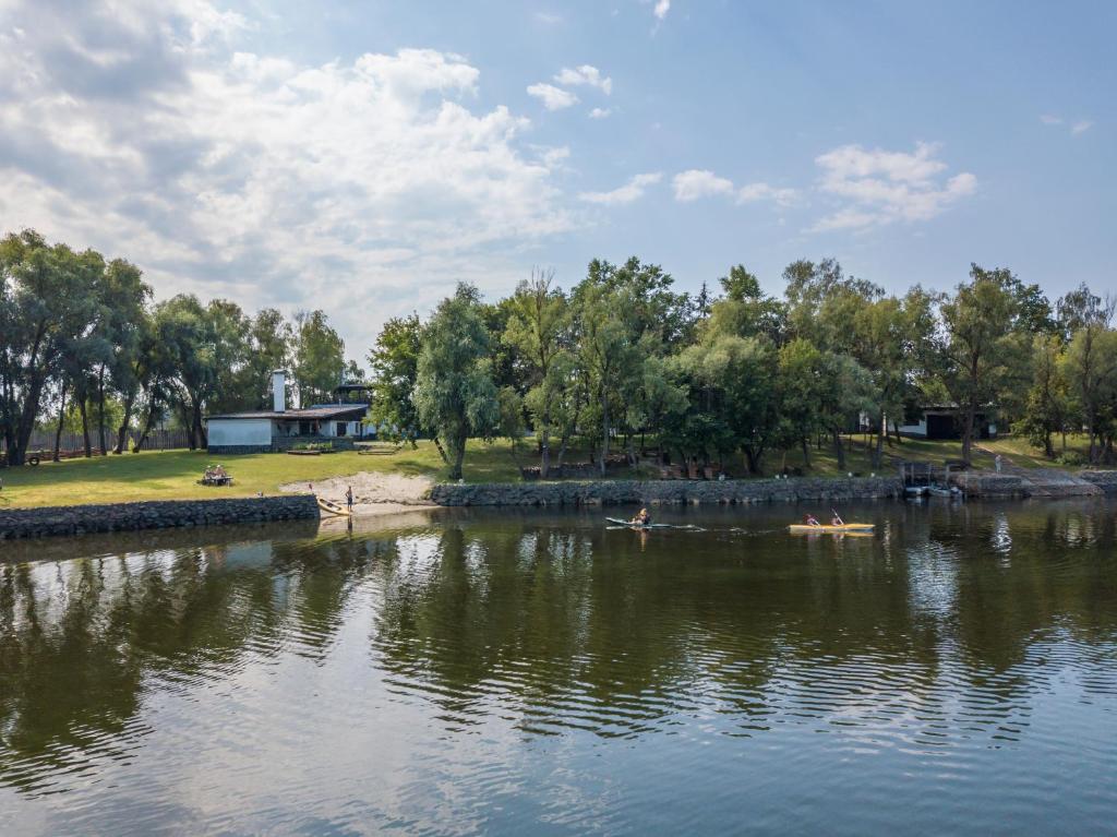 une rivière avec des gens nageant dans l'eau dans l'établissement Гостинний двір на хуторі Хрещатик, à Khreshchatik