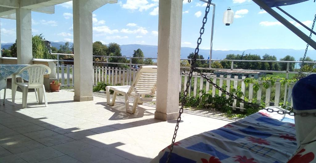 een veranda met 2 stoelen, een tafel en een schommel bij Marko Apartments in Struga