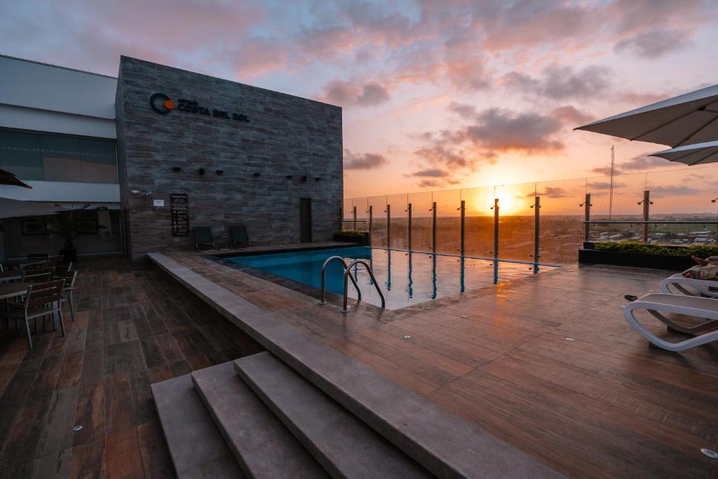 a swimming pool on a building with a sunset in the background at Costa del Sol Wyndham Tumbes in Tumbes