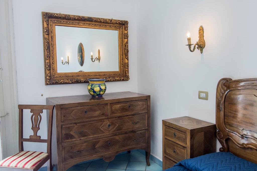 a bedroom with a dresser and a mirror at Hotel Fontana in Amalfi