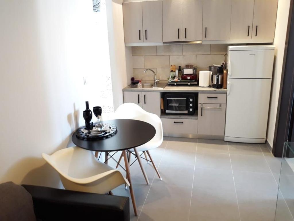 a small kitchen with a table and white appliances at Heart City Executive Suite in Chania