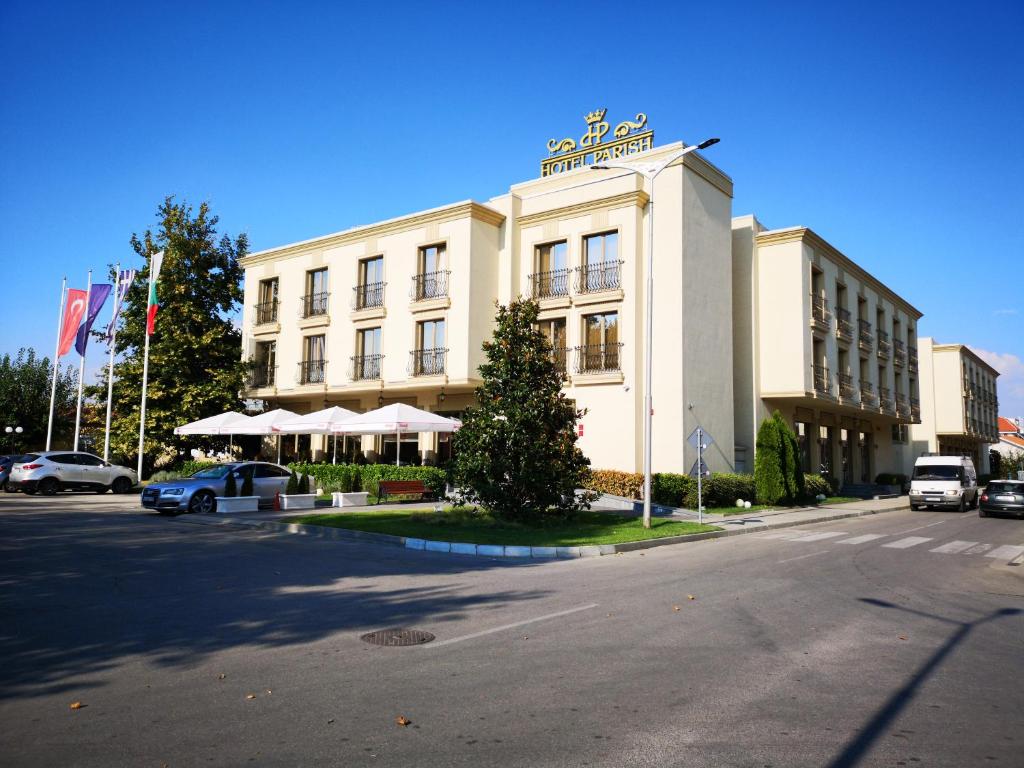 een groot wit gebouw met een bord erop bij Parish Hotel in Svilengrad