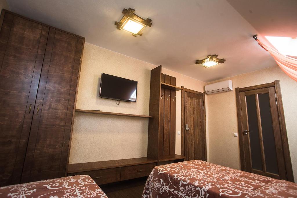 イジェフスクにあるRusskiy dvorのベッドルーム1室(ベッド1台、壁掛けテレビ付)