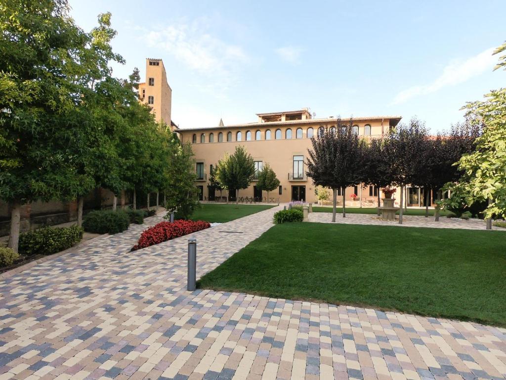 un patio de un edificio con césped y árboles en Les Clarisses Boutique Hotel, en Vic